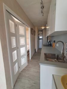 a kitchen with a sink and a door to a room at L'endroit in Bormes-les-Mimosas +13 photos