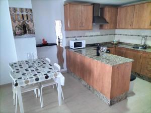 a kitchen with a counter and a table with chairs at Apartamento en playa de Moncofar con wifi y aire acondicionado in Moncófar +12 photos