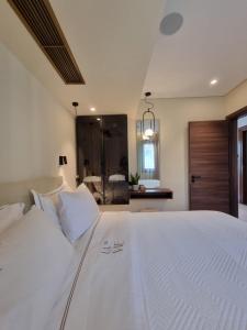 a bedroom with a large white bed with white pillows at La vie luxury suites in Megalochori +105 photos