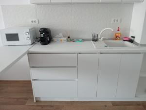 a white kitchen with a sink and a microwave at Nicholas Studio Saturn in Mangalia +5 photos