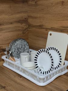 a white tray with dishes and plates and a laptop at Апартаменты в самом центре города in Balqash