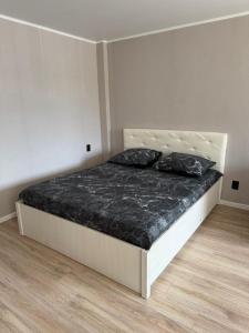 a bedroom with a bed with two pillows on it at Апартаменты в самом центре города in Balqash