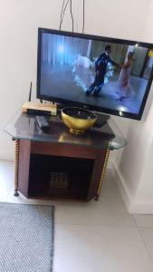 ein Fernseher auf einem Tisch mit einer Schüssel in der Unterkunft Chalé Luxuoso de Hospedes in Teresópolis