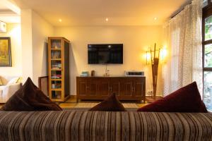 ein Wohnzimmer mit Couch und Flachbildfernseher in der Unterkunft Villa Nazuri w Caretaker in Candolim