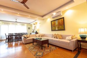 ein Wohnzimmer mit Sofa und Tisch in der Unterkunft Villa Nazuri w Caretaker in Candolim