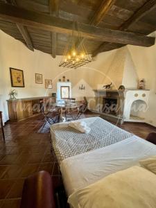 a room with a bed and a table and a chandelier at La Torre "UnaNotteaCasaMia" in Sacrofano