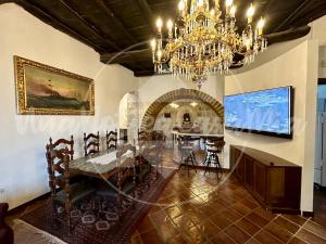 a dining room with a table and a chandelier at La Torre "UnaNotteaCasaMia" in Sacrofano