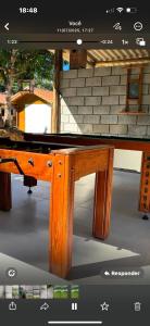 a wooden table with a table top on top of it at Pousada Hostels Foryou in Ibiraçu