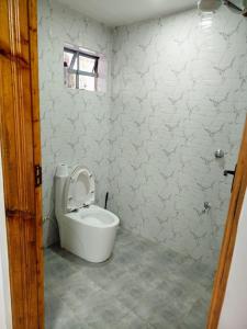 a bathroom with a toilet with the lid up at Four seventy in Meru +29 photos