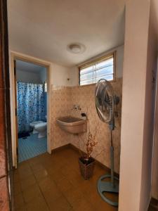 a bathroom with a tub and a sink and a fan at Refugio de Luz in La Falda +1 photo