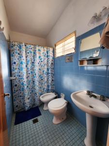 a blue bathroom with a toilet and a sink at Refugio de Luz in La Falda
