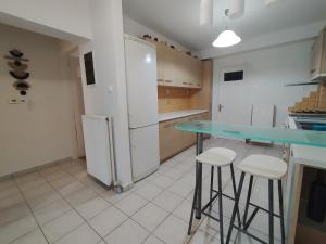 a kitchen with a refrigerator and a table and stools at Little Citrus Yard in Karlovasi