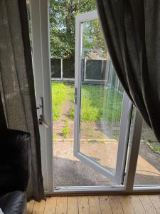 a sliding glass door with a view of a yard at Large double walking distance to NewCross Hospital in Fallings Park