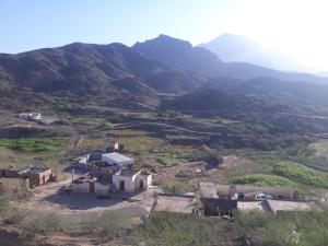 Al Majaridahにあるشقه مفروش بالمجاردةの山を背景にした丘の上の住宅