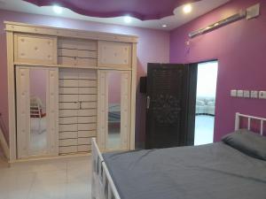 Al Majaridahにあるشقه مفروش بالمجاردةの紫の壁のベッドルーム1室(ベッド1台付)