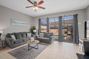 a living room with a couch and a ceiling fan at Vacation Fantasia - Mins to Disney - Pool & Hot Tub in Kissimmee
