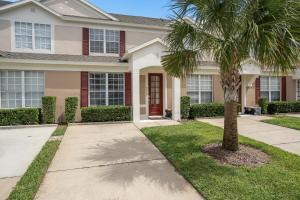 a house with a palm tree in front of it at Vacation Fantasia - Mins to Disney - Pool & Hot Tub in Kissimmee
