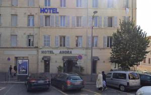 a hotel with cars parked in a parking lot at Anora in Marseille