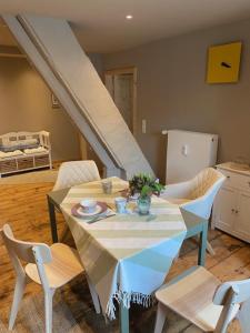 a dining room with a table with chairs and a staircase at Das Eulennest - wohnen in historischem Ambiente in Brake