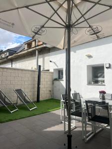 un tavolo e delle sedie sotto un ombrellone in un patio di Casa Barrionuevo 1 a Segovia