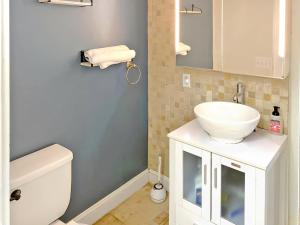 a bathroom with a white sink and a toilet at Corporate Housing, Upgraded Condo Downtown Hoboken in Hoboken +24 photos