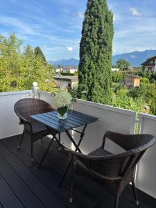 a table and chairs on a deck with a view at Ferienwohnung Julia - Ruhelage mit Panoramablick in Villach