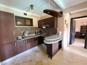 a kitchen with wooden cabinets and a counter top at Palm river marrackech in Marrakesh