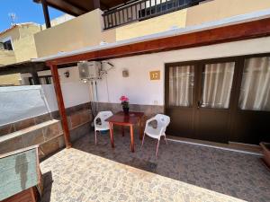 a patio with two chairs and a table on a building at Neptuno 12 in Caleta De Fuste