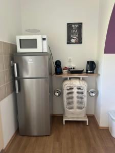 a kitchen with a refrigerator and a microwave and a table at Apartment Kix in Rab +16 photos