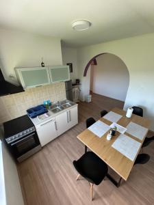 a kitchen with a wooden table and a table and chairs at Apartment Kix in Rab