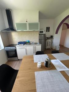 a kitchen with a table and a kitchen with a sink at Apartment Kix in Rab