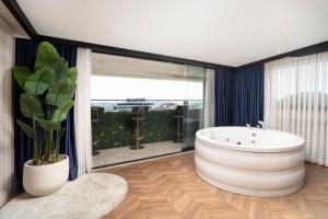 a bathroom with a large tub and a plant at Walton Gardens Pera in Istanbul +99 photos