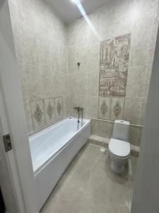a bathroom with a white tub and a toilet at Royal resort in Aktau +16 photos