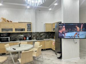 a room with a kitchen with a tv and a table at Royal resort in Aktau