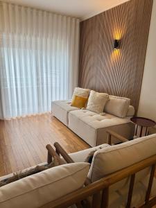 Porta14 Praia في بوفوا دي فارزيم: غرفة معيشة بها كنبتين بيضاء ونافذة