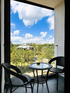 a table and chairs on a balcony with a view at Penthouse Studio Borovi in Divčibare