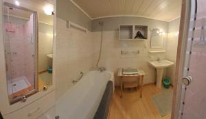 a bathroom with a bath tub and a sink at Les VIGNEAUX Hautes Alpes, Appartement 4 personnes, avec belle terrasse panoramique in Les Vigneaux +35 photos
