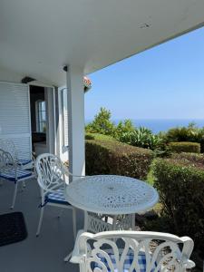 einen Tisch und Stühle auf der Veranda eines Hauses in der Unterkunft Villa Ferreirinha in Santa Cruz das Flores