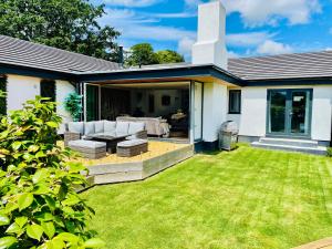a backyard of a house with a lawn at The Cuckoo's Retreat - Luxurious home with private garden & jacuzzi in Kenwyn