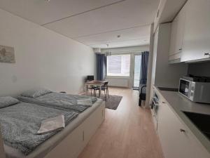 a bedroom with a bed and a kitchen with a table at Easy Stay Rooms & Apartments near Airport in Vantaa