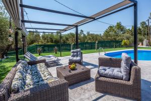 a patio with wicker furniture and a swimming pool at Casa NickAntony in Kalpaki