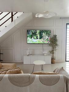 a living room with a flat screen tv on the wall at Maison de Jacinta - 2BR HOUSE NEAR AGUINALDO HIGHWAY in Dasmariñas
