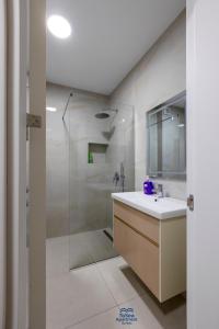 a bathroom with a shower and a sink and a mirror at ToSea Apartment by Melia in Lalzit Bay
