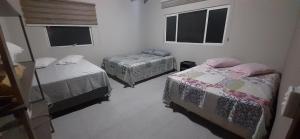 a room with two beds and two windows at A Casa TOP da Região in Matinhos