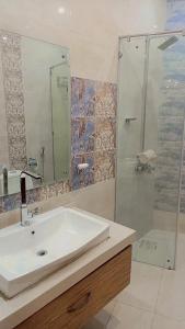 a bathroom with a sink and a glass shower at Peaceful Hilltop Apartment in Changla Gali in Chhāngla Gali