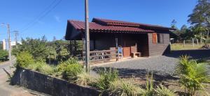 a small wooden cabin with a porch at Chalé Mirante do Salto in Rio Forcação