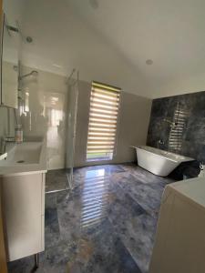 a bathroom with a tub and a sink and a bath tub at Family house in Valmiera +6 photos