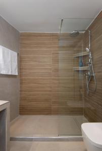 a bathroom with a shower with a glass door at Θεμωνιά house in Káto Petálion