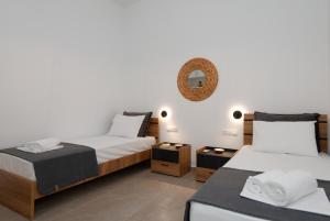 a bedroom with two beds and a mirror on the wall at Θεμωνιά house in Káto Petálion