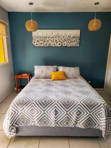 a bedroom with a large bed with a blue wall at Pipas Apartment I Walk to the beach in Tamarindo +20 photos